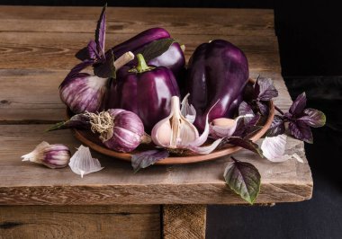  Fesleğen yapraklı koyu mor biber ve siyah arka planda eski ahşap masa üzerinde sarımsak.. 