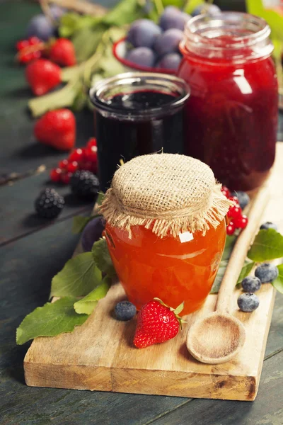 Frutas e geléia de baga em um fundo de madeira — Fotografia de Stock