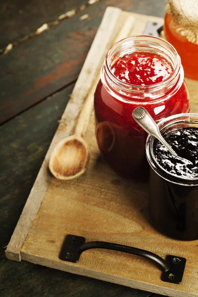 Fruit and berry jam on a wooden background — Stock Photo, Image