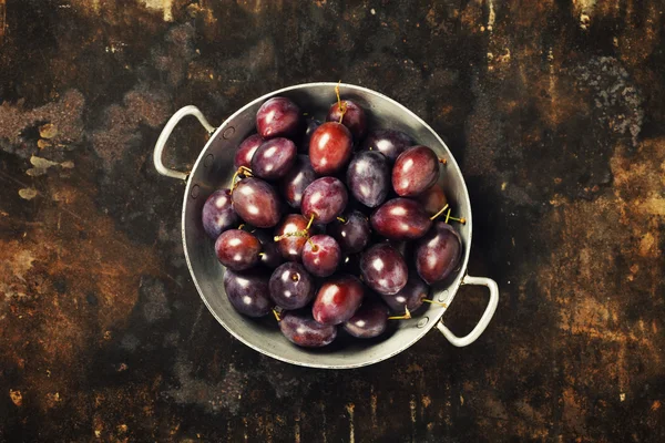 Plums in a bowl on a rural background — Stock Photo, Image