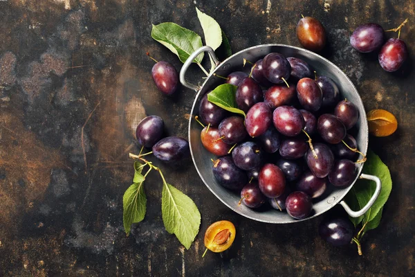 Plums in a bowl on a rural background — Stock Photo, Image