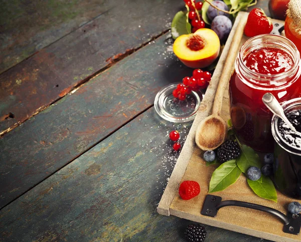 Fruit en bessen jam op een houten achtergrond — Stockfoto