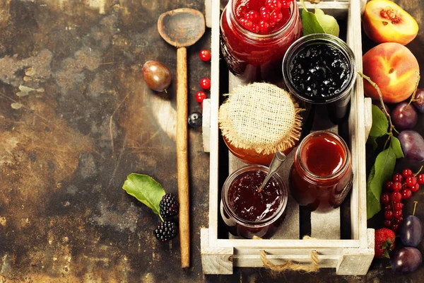 Ovoce a bobuloviny jam na rustikální pozadí — Stock fotografie