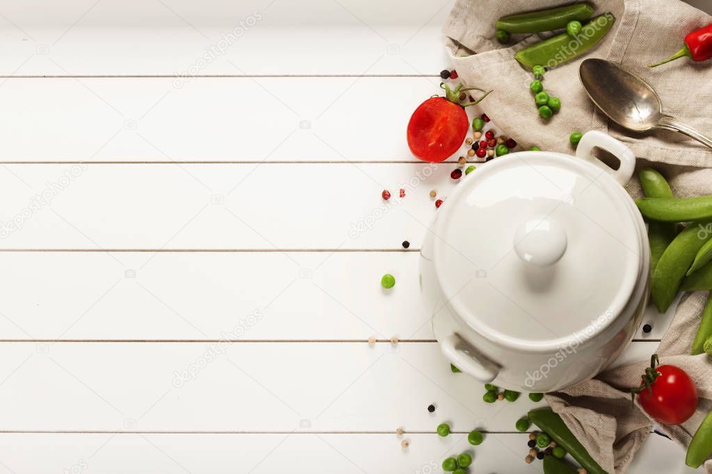 White cooking pot and ingredients for soup or stew