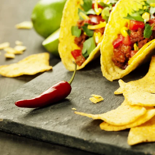 Mexican nachos chips and tacos with meat, beans and salsa — Stock Photo, Image