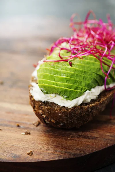 Sandwich de aguacate sobre pan de centeno oscuro hecho con aguacate fresco en rodajas —  Fotos de Stock