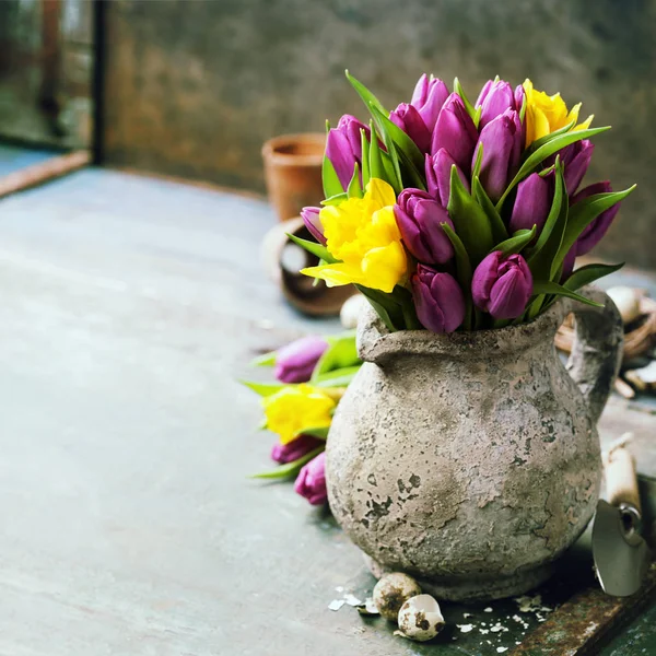 Bonito buquê de tulipas primavera, ovos de Páscoa e ferramentas de jardim — Fotografia de Stock