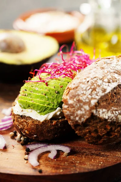 Sandwich de aguacate sobre pan de centeno oscuro hecho con aguacate fresco en rodajas —  Fotos de Stock