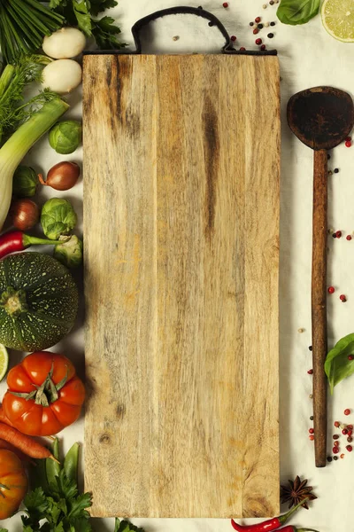 Vegetables, herbs, spices and empty cutting board — Stock Photo, Image