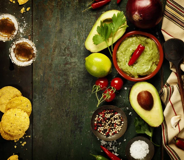 Tigela de guacamole com ingredientes frescos e tiros de tequila — Fotografia de Stock