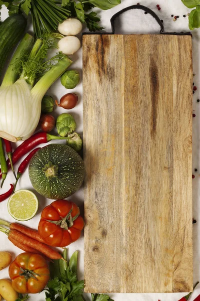Grøntsager, urter, krydderier og tomt skærebræt - Stock-foto