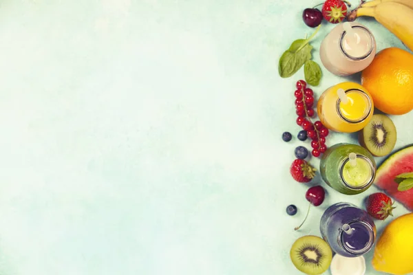 Свіжі соки або смузі з фруктами та овочами на блакитному фоні — стокове фото