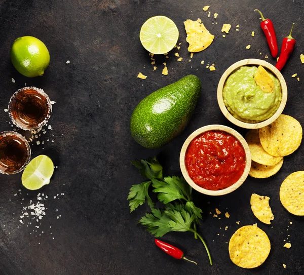 Grön hemmagjord Guacamole med tortillachips, Salsa och tequila — Stockfoto