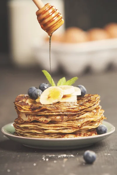 Homemade pancakes with fresh bananas, blueberries and honey — Stock Photo, Image