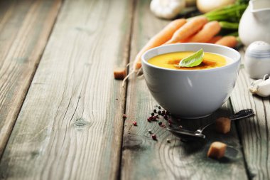 Eski ahşap arka plan üzerinde bir kapta krem sebze çorbası