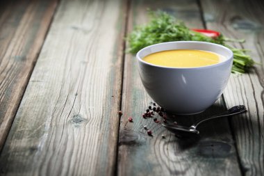 Eski ahşap arka plan üzerinde bir kapta krem sebze çorbası