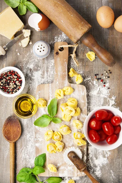 Tortellini pasta italiana cruda sobre tabla de madera — Foto de Stock