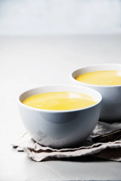Pompoen crème soep in kom over grijze concrete achtergrond — Stockfoto