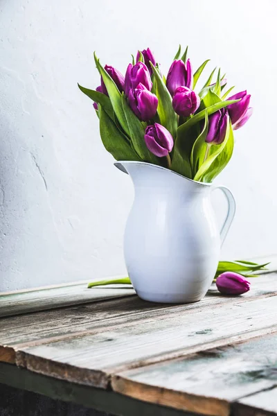 Un ramo de tulipanes morados en un jarrón — Foto de Stock