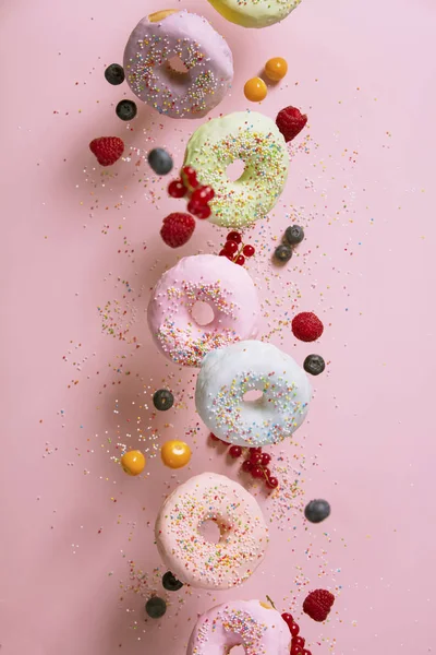 Sweet and colourful doughnuts falling or flying in motion — Stock Photo, Image