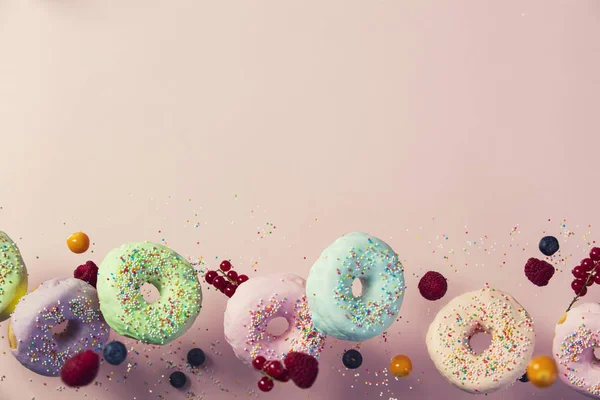 Donuts doces e coloridos caindo ou voando em movimento — Fotografia de Stock