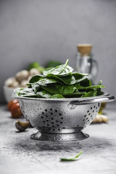 Fresh organic spinach leaves in metal colander and healthy ingre — Stock Photo, Image