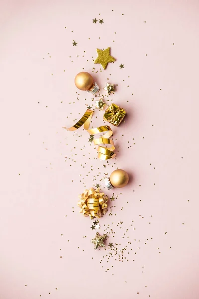 Platte uitvoering van de viering. Golden Christmas decoraties op roze achtergrond — Stockfoto