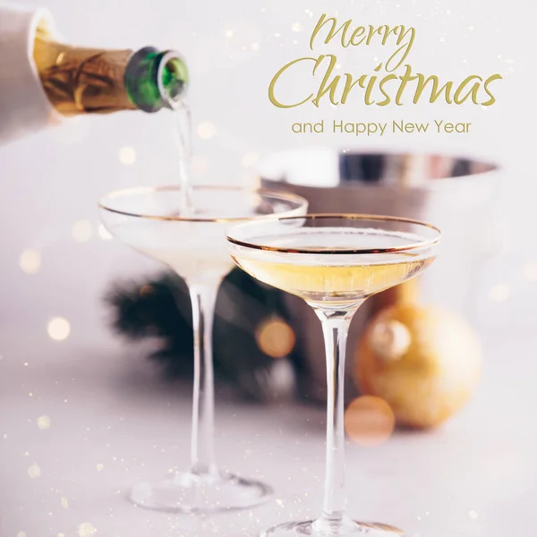 Champagne versato in bicchieri e decorazioni natalizie con testo — Foto Stock