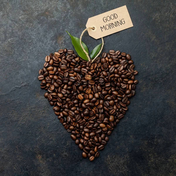 Grãos de café em forma de coração no fundo rústico escuro — Fotografia de Stock
