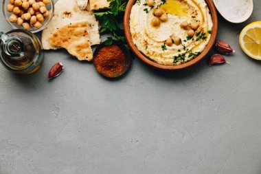 Nohut, kırmızı tatlı biber, maydanoz ve zeytinyağıyla süslenmiş büyük bir kâse ev yapımı humus.