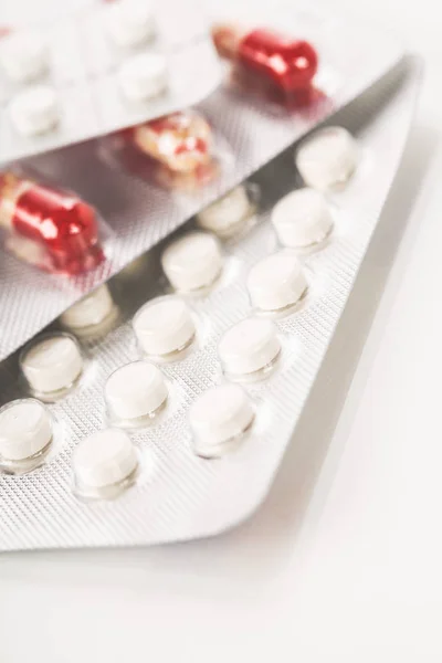 Comprimidos, comprimidos e cápsulas de medicamentos variados sobre fundo branco — Fotografia de Stock