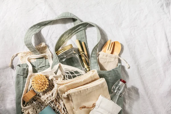 Concept zéro déchet. Éco-sacs textiles, bocaux en verre, vaisselle recyclée en bambou sur fond de lin — Photo