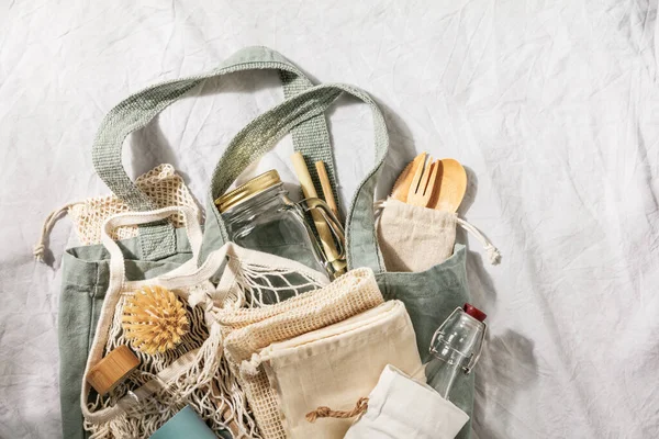 Zero waste concept. Textile eco bags, glass jars, bamboo recycled tableware on linen background — Stock Photo, Image