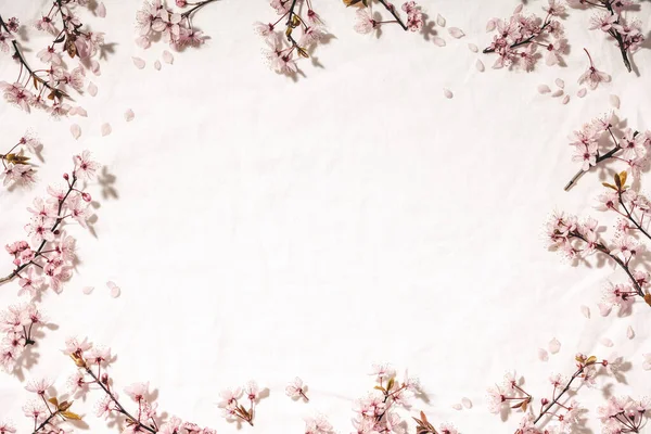 Ανοιξιάτικο περίγραμμα με άνθη κερασιάς σε λευκή λινή πετσέτα — Φωτογραφία Αρχείου