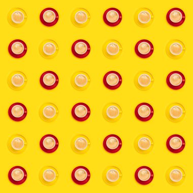 Sarı arkaplanda renkli kahve fincanları var.