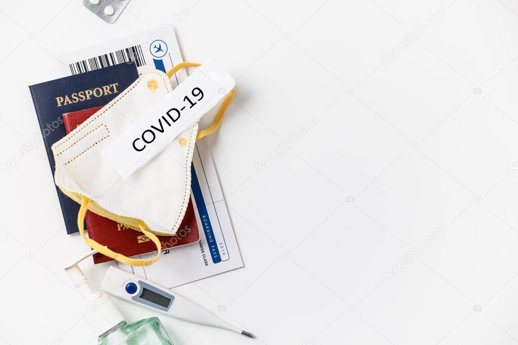 Coronavirus and travel concept. Passports, airplane tickets and medical mask flat lay.