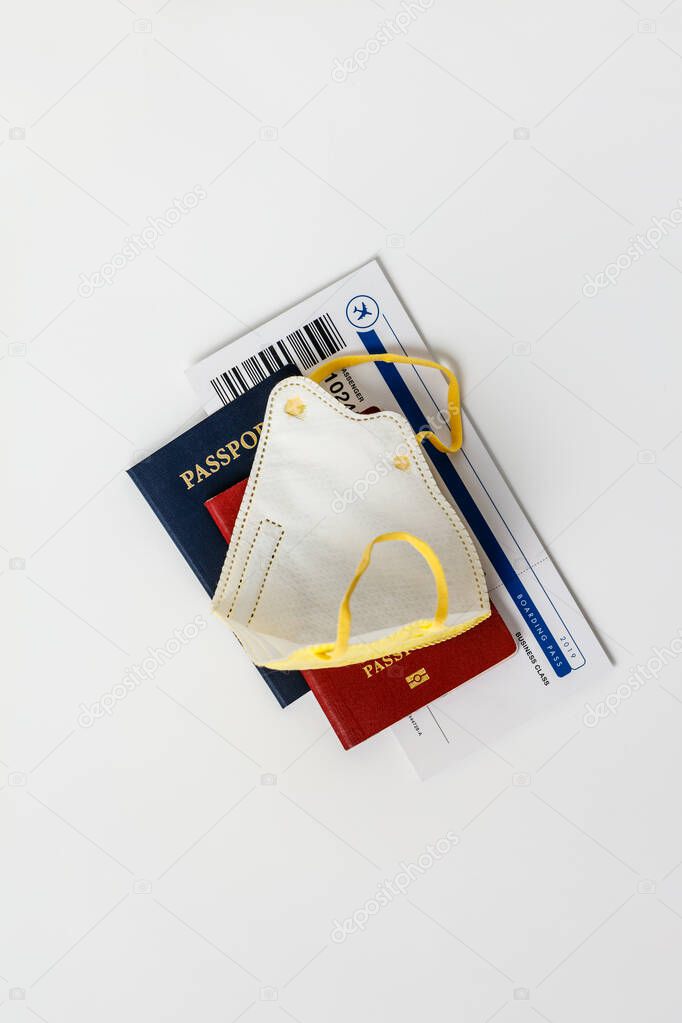 Coronavirus and travel concept. Passports, airplane tickets and medical mask flat lay.