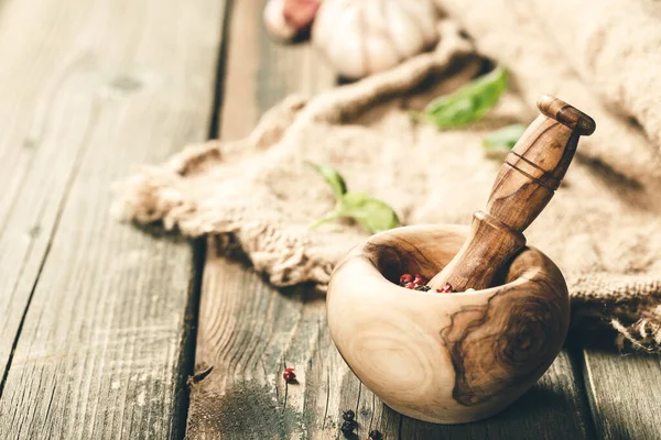 Kochhintergrund. Holzmörtel und Stößel, Kräuter und Gewürze, Kopierraum — Stockfoto