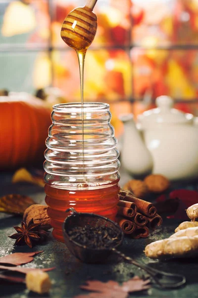 Herfstcompositie. Potje honing, pompoenen en specerijen op houten raam — Stockfoto