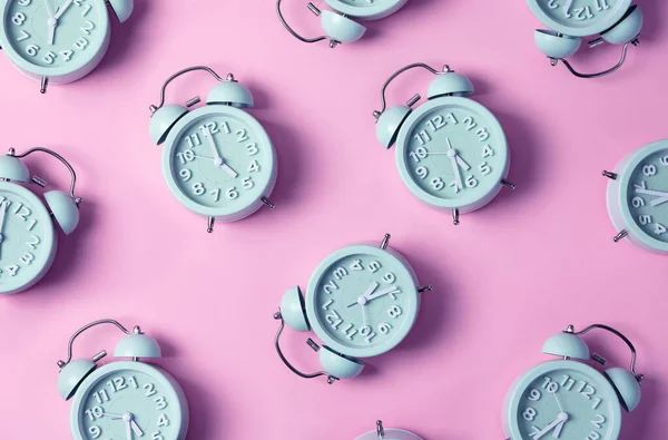 Creative layout of blue alarm clocks on pastel pink background. Minimal concept — Stock Photo, Image