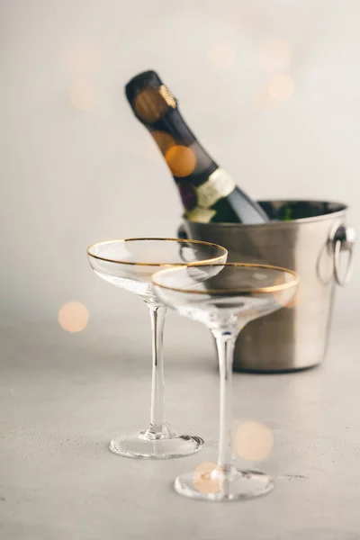 Champagne fles in emmer met ijs en glazen, verticale samenstelling — Stockfoto