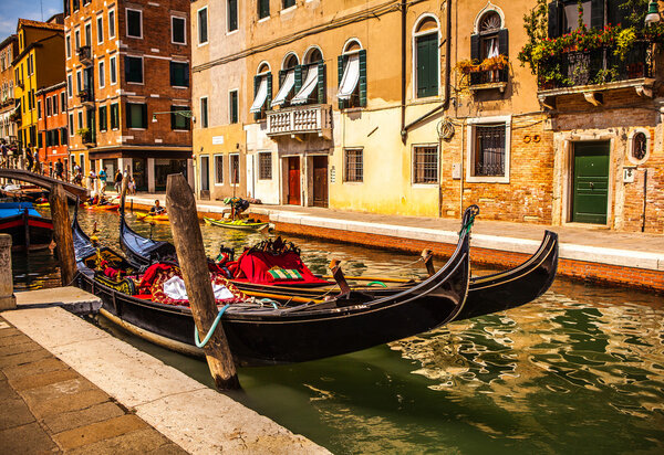 VENICE, ITALY - AUGUST 17, 2016: Traditional gondolas on narrow canal close-up on August 17, 2016 in Venice, Italy.