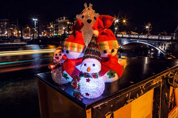 Szilveszteri játékok hóembert és a szarvas jelentenek ellen night csatornákon, az Amszterdami. — Stock Fotó