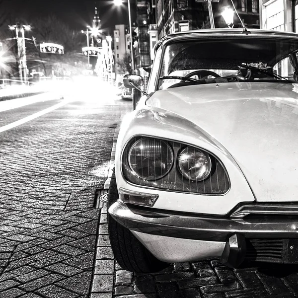 老式的白色汽车停放在阿姆斯特丹中心在夜间. — 图库照片