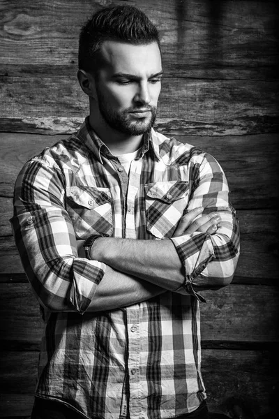 Retrato blanco y negro del joven guapo hombre de moda contra la pared de madera . —  Fotos de Stock