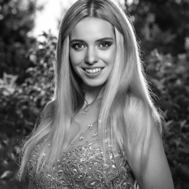 Şık elbiseli güzel genç gülümseyen, siyah-beyaz açık portre sarışın kadın.