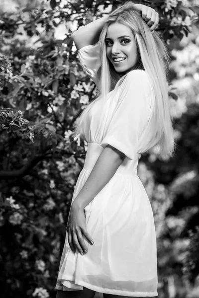 Fekete-fehér kültéri portréja gyönyörű fiatal mosolygós szőke nő elegáns ruha. — Stock Fotó