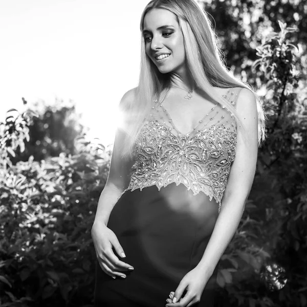 Black-white outdoor portrait of beautiful young smiling blond woman in stylish dress. — Stock Photo, Image