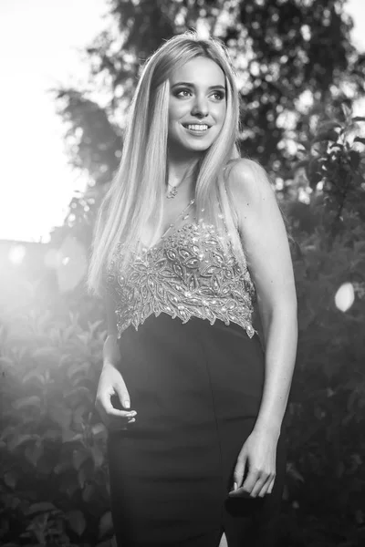 Black-white outdoor portrait of beautiful young smiling blond woman in stylish dress. — Stock Photo, Image