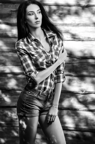 Młody zmysłowy Idealna kobieta uroda brunetka stanowią drewniane tle. Fotografia czarno biała. — Zdjęcie stockowe